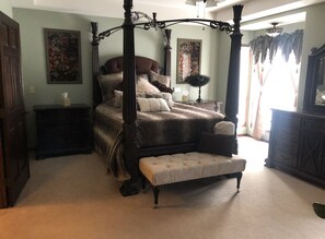 Classic four-poster bed with a matching bench and elegant furnishings.