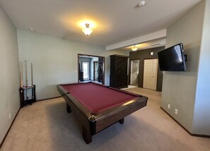 Enjoy a game of pool or watch your favorite show on the mounted TV in this spacious room.