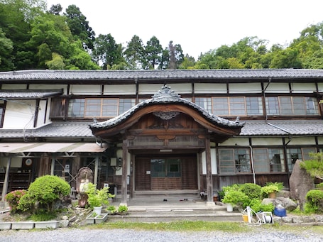A traditional Japanese building with a wooden entrance, multiple windows, and a tiled roof.