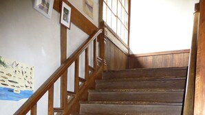 Un escalier en bois avec une rampe, des murs en bois et un tableau encadré accroché au mur.