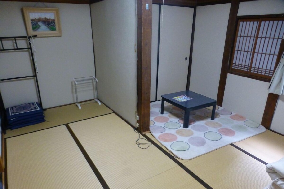 A tatami mat room with a small table, a shelf, and a picture on the wall.