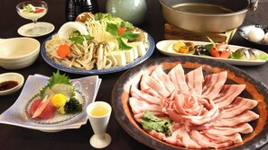 A variety of dishes including sashimi, vegetables, and a large pot, suggesting a dining setting. - Tsurunoyu Onsen (Minabe)