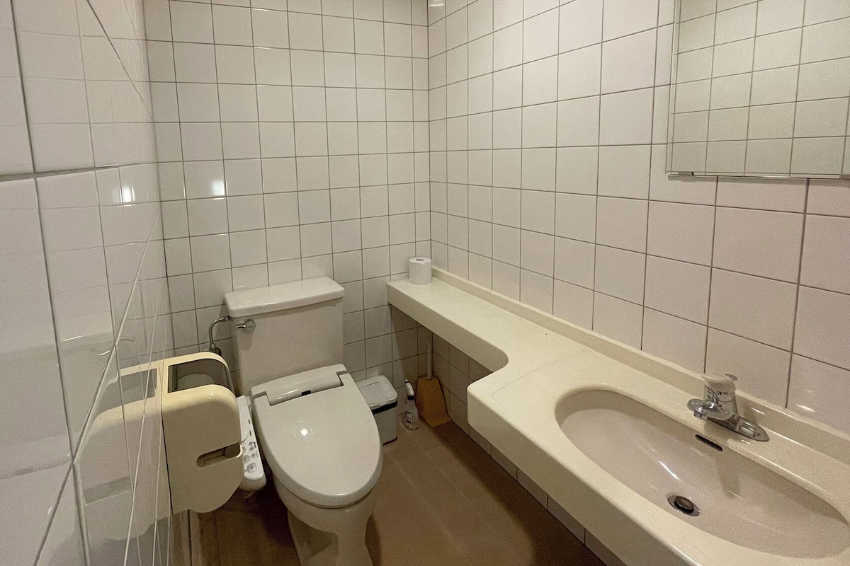 A small, clean bathroom with a toilet, sink, and a mirror above the sink.