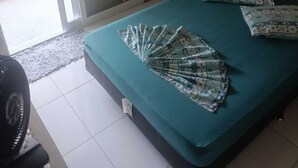 A bedroom with a bed, a fan, and a sliding glass door leading to an outdoor area. - Pousada Cavalo de Pedra (Peruíbe)