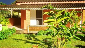 A house with a tiled roof, a brick exterior, and a small front porch. - Pousada Cavalo de Pedra (Peruíbe)