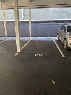 Een parkeergarage met een auto geparkeerd op een plek met nummer 28.
