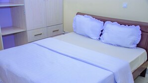 Una camera da letto con un letto, un armadio e un comodino.