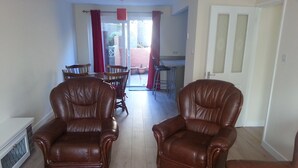 A living room with two brown leather armchairs, a red rug, and a view into a dining area with a table and chairs. - House - Sleeps 5 - Pets Ok - Parking - Garden (Bristol)