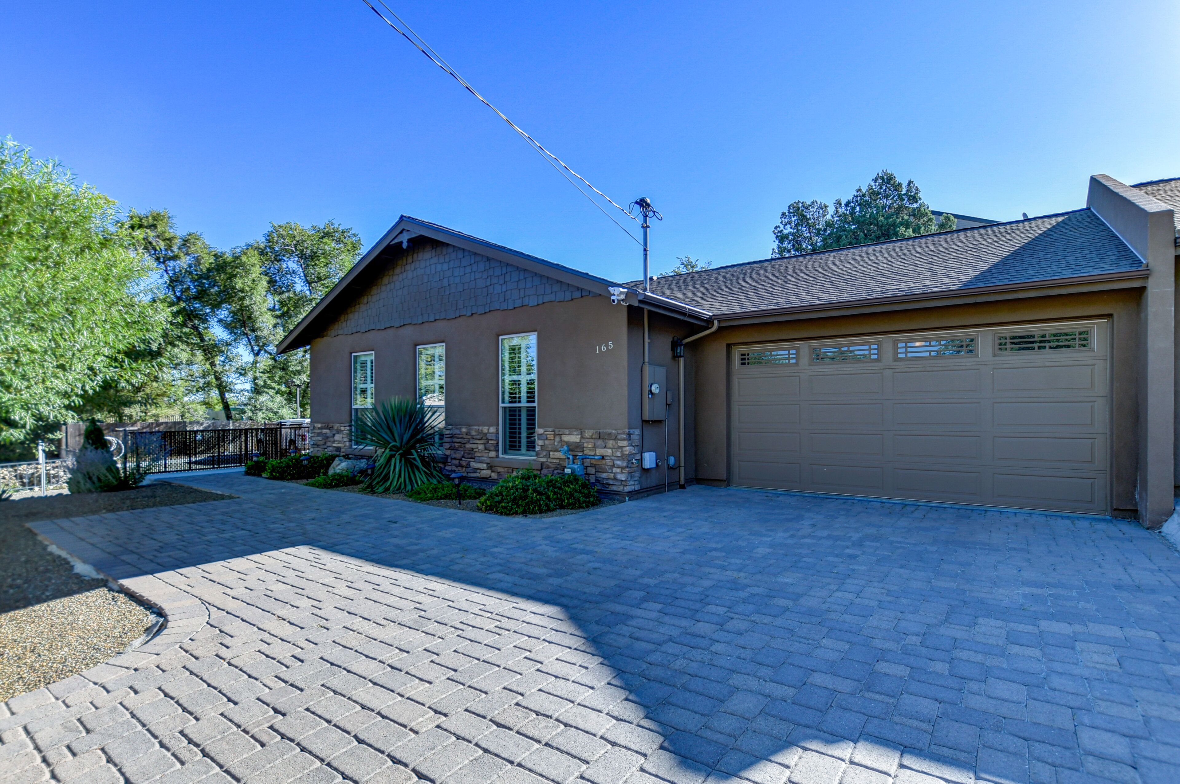 A two-story house with a garage, paved driveway, and landscaping.