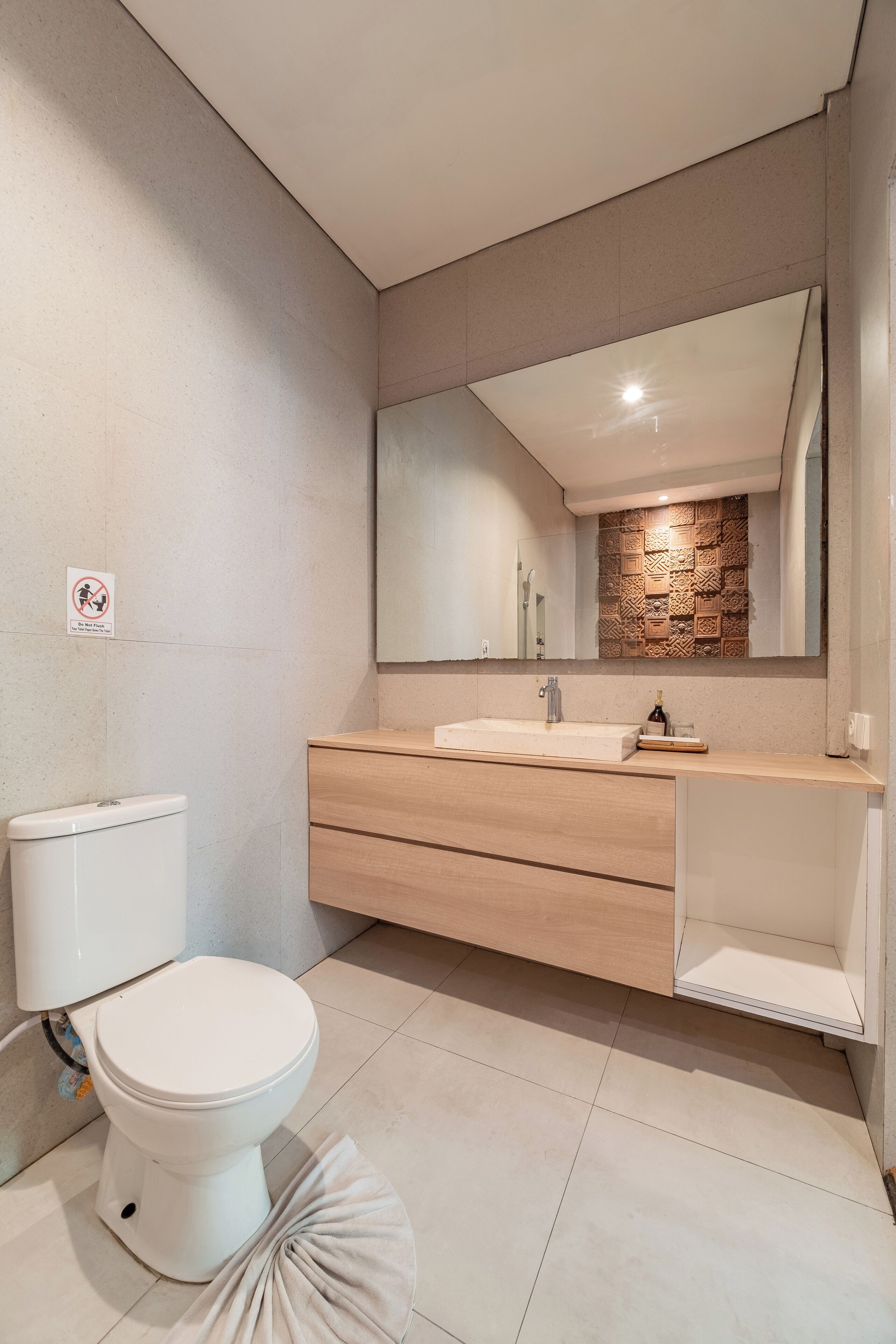 A modern bathroom with a toilet, a sink, and a mirror.