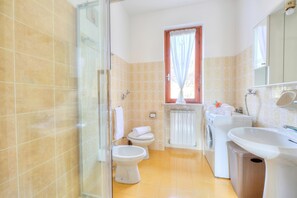Een douche, een haardroger, een bidet, handdoeken