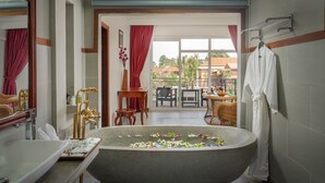 A bathroom with a freestanding bathtub, a sink, and a mirror.