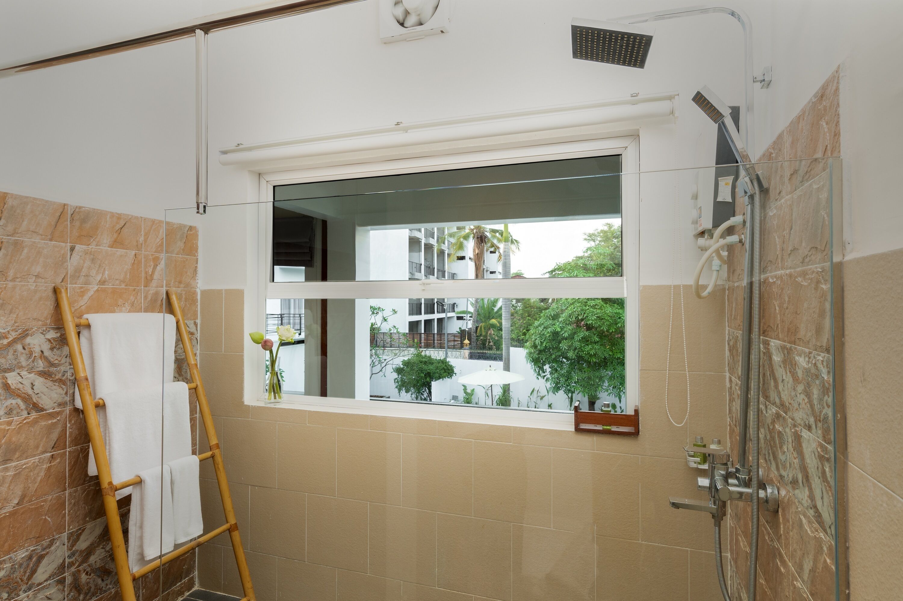 A bathroom with a shower, a window, and a towel rack.