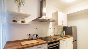 Una cocina moderna con campana extractora de acero inoxidable, horno empotrado, un lavamanos y encimera de madera.