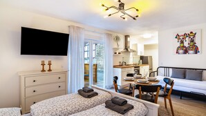 Una habitación de hotel moderna con una cama, un escritorio, un sofá, un televisor y un cuadro.