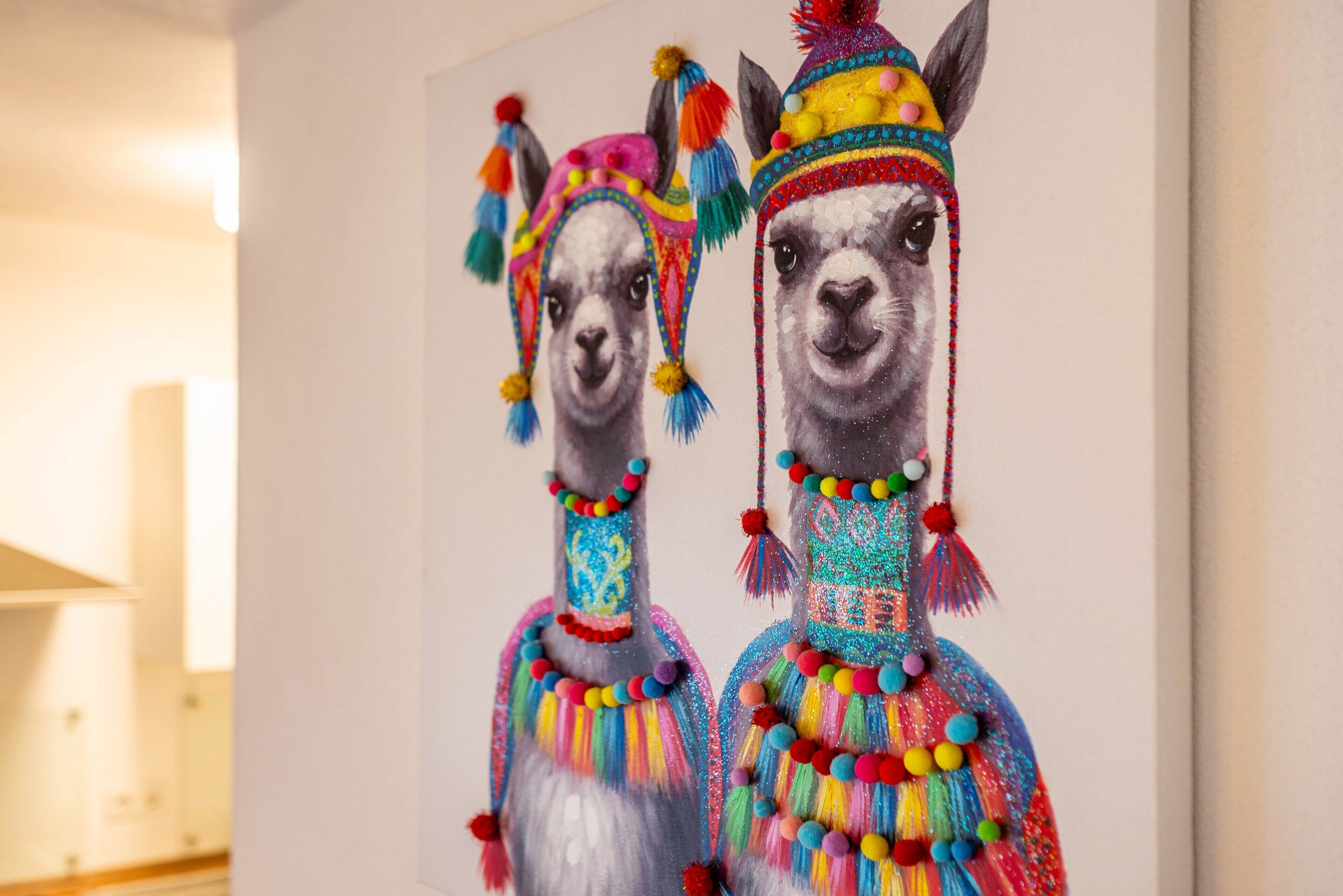 Un mur orné de deux sculptures de lamas aux couleurs vives.