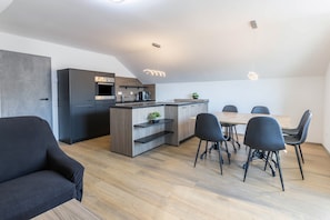 Une cuisine moderne avec un coin repas, comprenant un canapé et des chaises.