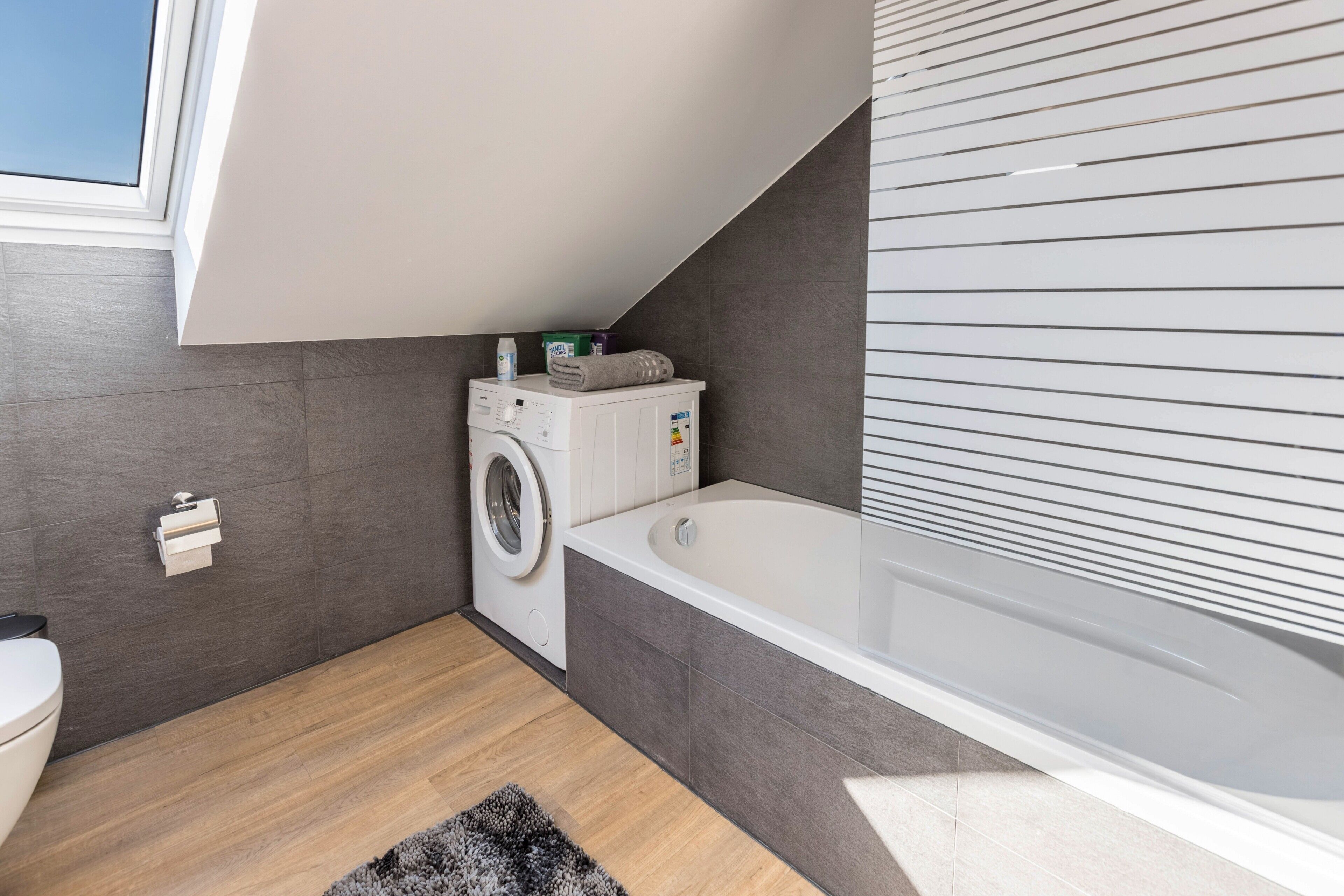 Un bagno moderno con lavatrice, vasca e servizi igienici.