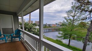 Ein überdachter Balkon mit Blick auf einen Fluss und Gebäude im Hintergrund.
