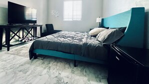 A bedroom with a bed, a television on a stand, a ceiling fan, a window, and a nightstand with a lamp. - Luxury Gated Retreat – Resort Amenities, Pool, Spa, Gym (Mesa)