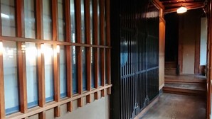 En traditionell japansk inredning med skjutdörrar i trä och en trappa som leder upp till en övre våning.