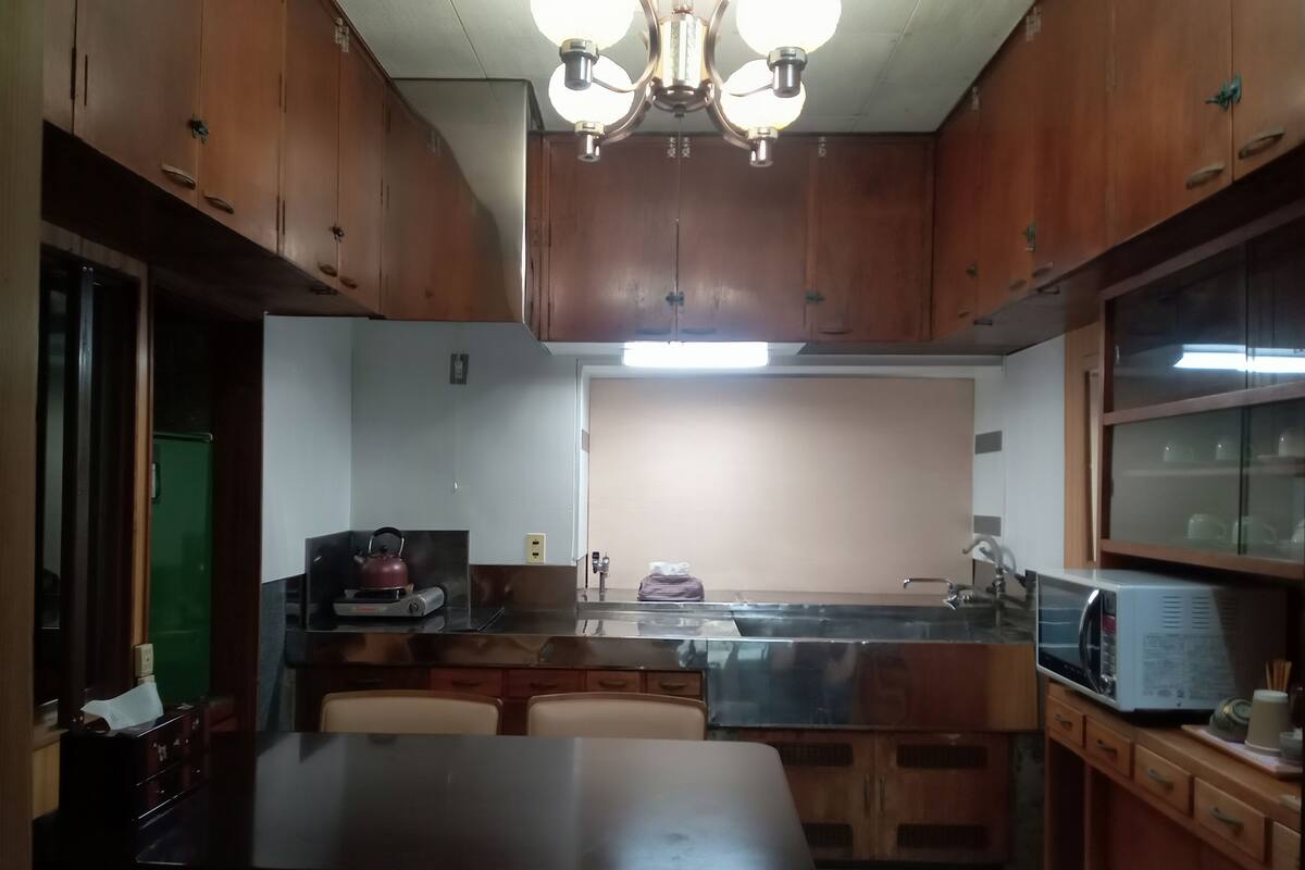 Una cocina con armarios de madera, una mesa de comedor y un microondas integrado.