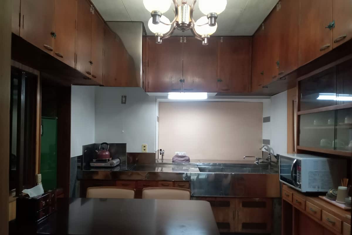 A kitchen with wooden cabinets, a dining table, and a built-in microwave.
