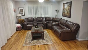 A living room with a sectional sofa, a coffee table, a floor lamp, and a ceiling fan. - Self Check-In & Free Wi-Fi in this Fresh Remodel! (Idaho Falls)