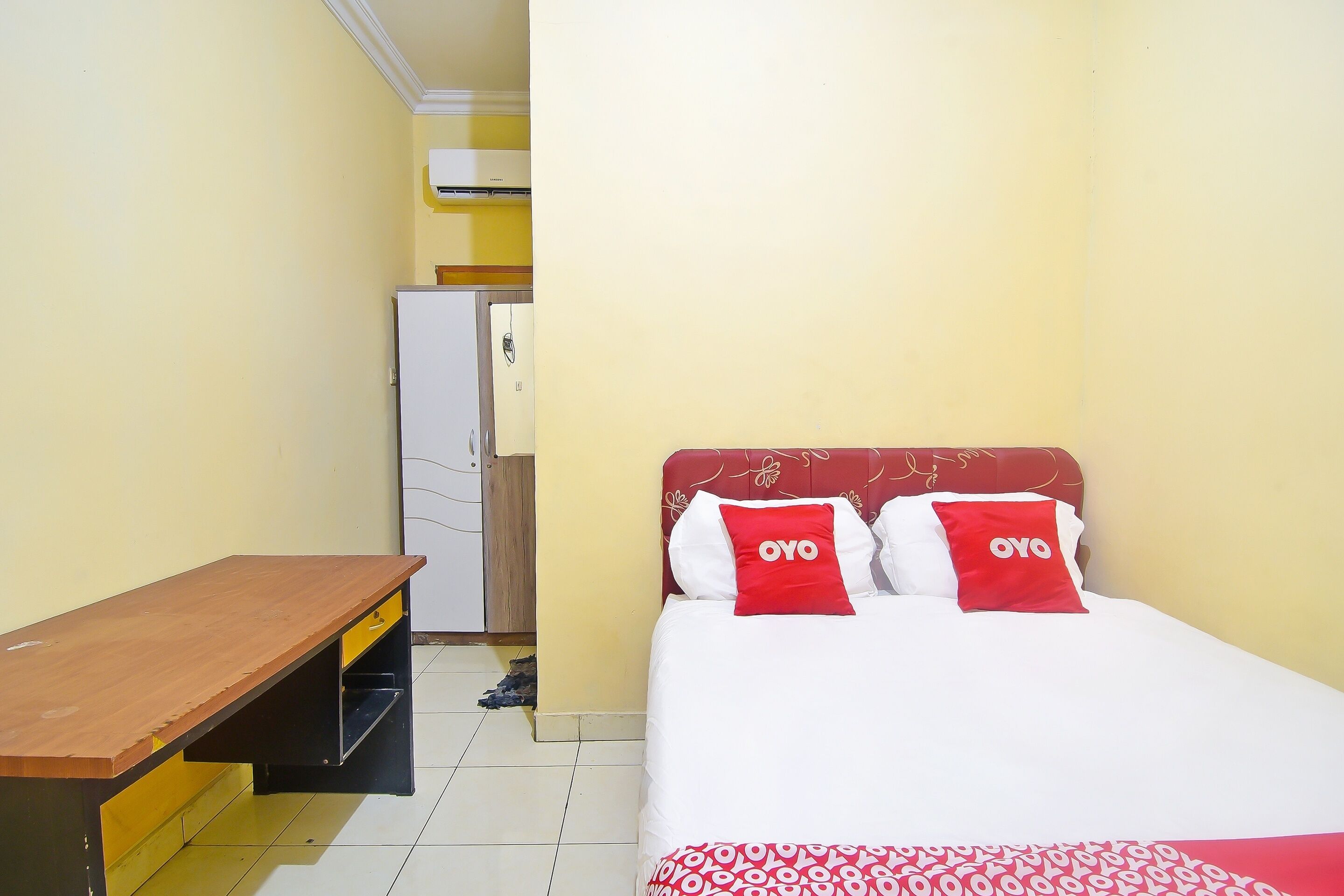 Una habitación de hotel pequeña con cama, escritorio y armario.