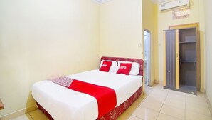 A hotel room with a bed, a wardrobe, and an air conditioning unit. - Hotel O A2b Guesthouse (Manado)