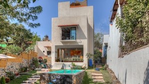 A modern house with a swimming pool, a balcony, and a stone pathway leading to the entrance. - Casa Ehua Hotel Galería (Tepoztlán)