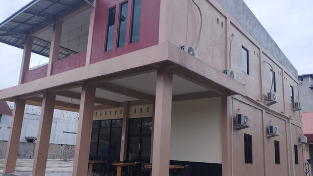 A two-story building with a covered patio area and outdoor seating.