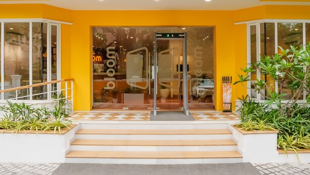 Un edificio amarillo con el letrero "bloom boutique" sobre la entrada.