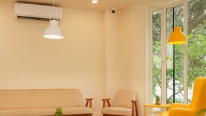 Una sala de estar moderna con un sofá, sillas, una mesita de centro y un sillón amarillo brillante.