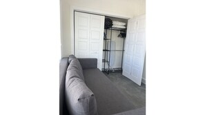 Cozy living space with a sofa and closet with ample storage.