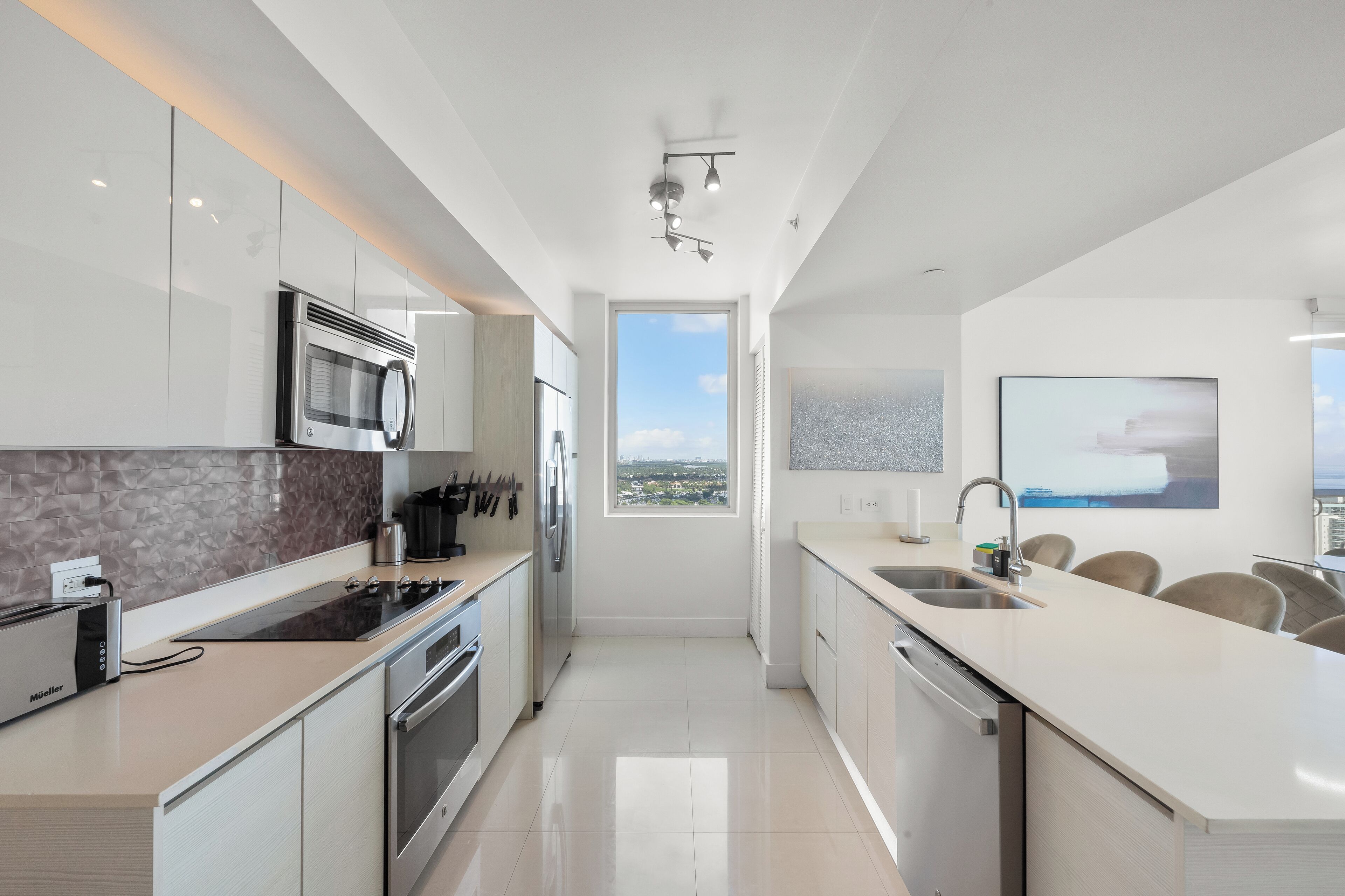 A modern kitchen with a view to the outside, a built-in microwave, and a toaster.