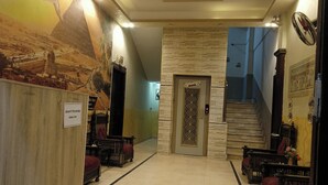 A lobby with a view of the desert pyramids, a reception desk, and a staircase leading to upper floors. - Falcon pyramids inn (Giza)