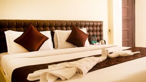 A neatly made bed with a brown headboard, white and brown pillows, and a brown throw blanket. - White Haven Luxury Villa (Kilvelur)