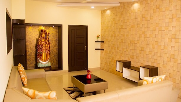 A modern living room with a sofa, a coffee table, and a decorative statue. - White Haven Luxury Villa (Kilvelur)