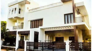 A modern two-story house with a flat roof, large windows, and a balcony. - White Haven Luxury Villa (Kilvelur)