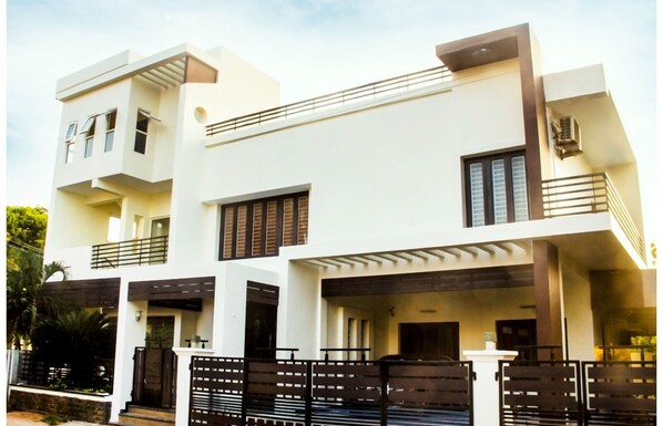 Stylish two-story building with a clean, minimalist design and a prominent balcony.