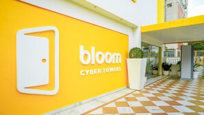 A building entrance with a yellow wall and a sign reading "bloom Cyber Towers." - Bloom Hotel - Cyber Towers (Hyderabad)