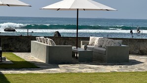 A patio with outdoor furniture, a stone floor, and a view of the ocean. - IF Villa in Unawatuna (Unawatuna)