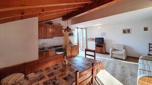 A rustic kitchen with wooden cabinets and a dining table set for four.