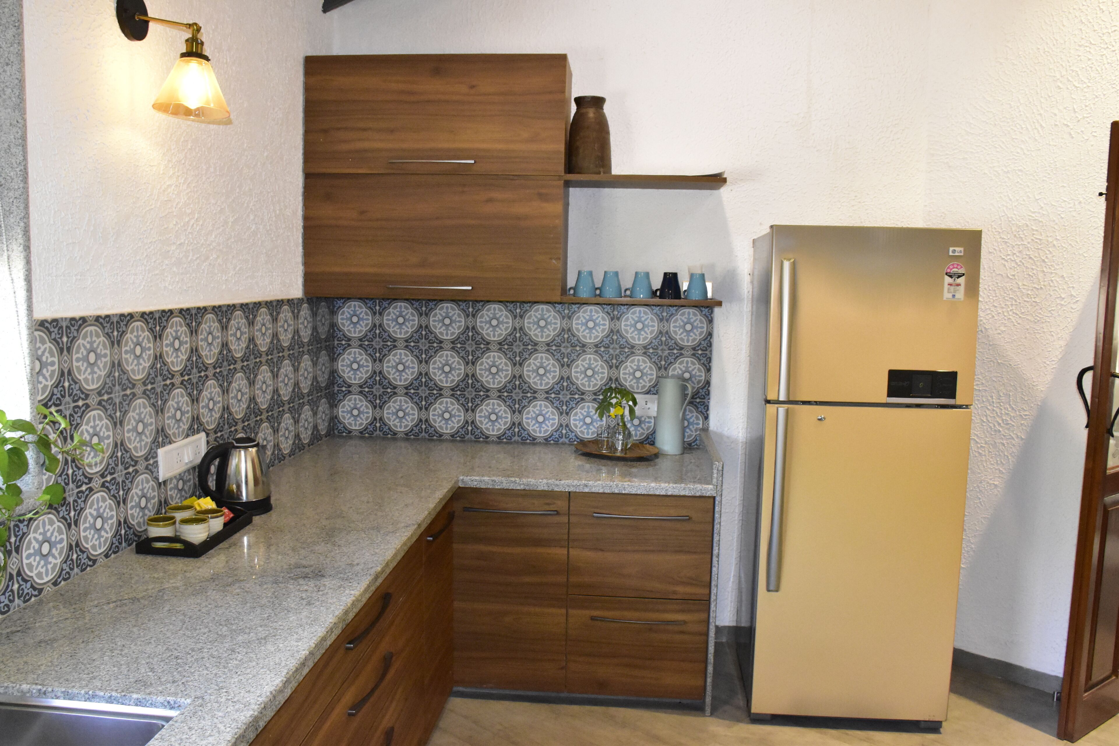 A kitchen with a wooden cabinet, a beige refrigerator, and a tiled backsplash.