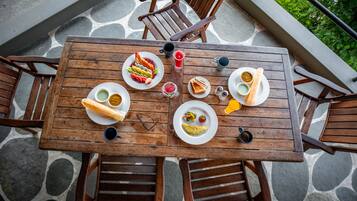 Una mesa de madera con platos de comida, vasos y cubiertos.