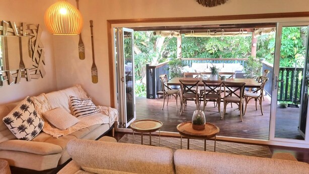 A cozy living area with a sofa, a small table, and a dining set. - Magnetic Mango Escape (HORSESHOE BAY)
