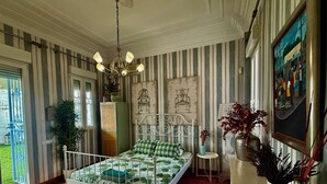 Ein Zimmer mit einem Bett, einem kleinen Tisch, einem Stuhl, einem Fenster und einer Tür.