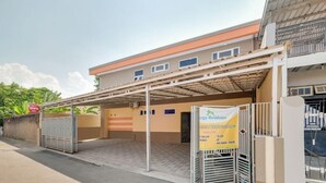 Un edificio con zona de estacionamiento techada y un cartel que indica Omega Residence.