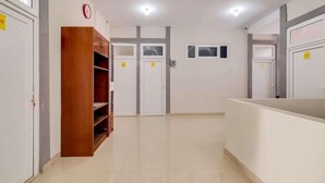 Un pasillo con puertas blancas, un armario de madera y una mesa de recepción.